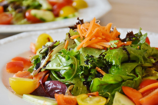 Bunte Auswahl an frischen, knackigen Salaten mit Gemüse und Dressing